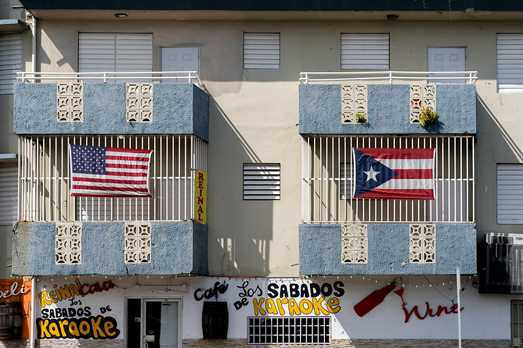United States and Puerto Rican flag on a building in Puerto Rico in 2018. Photo courtesy of Lorie Shaull via Flickr.